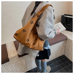 Détails de texture du sac fourre-tout en daim jaune gingembre avec motifs ajourés