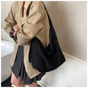 Model wearing a large black minimalist hobo bag for women with wide shoulder strap