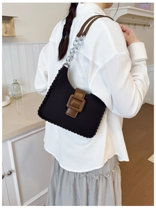 Détail d'un sac à bandoulière vintage avec boucle en cuir marron et bordure tissée unique