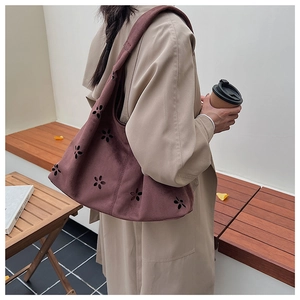 Détails du motif floral découpé au laser sur le sac cabas en daim bordeaux chic