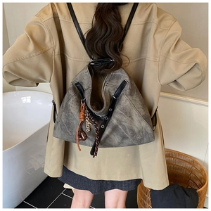 Detail of vintage gray faux leather tote bag with stylish fringe and metal hardware