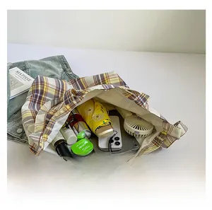 Internal view showing large capacity of plaid tote bag with tablet and daily items