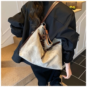 Detail showing high-capacity vintage tote with grey canvas texture and brown leather strap