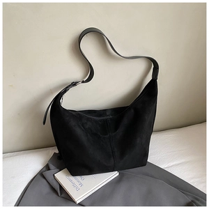 Detail of black faux suede hobo bag with adjustable strap and silver metal buckle