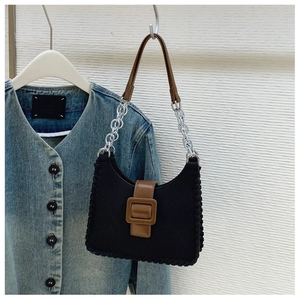 Détail d'un sac vintage bicolore avec bords tissés et bandoulière en chaîne argentée