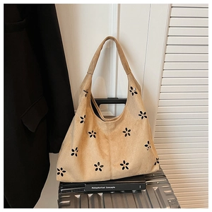 Détail du motif floral découpé au laser sur le sac cabas en daim kaki au design élégant