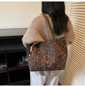 Detailansicht der Leo-Print-Tasche mit Perlenanhänger und schmalen Schultergurten