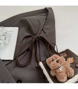 Detail of adjustable brown leather strap and plush fleece trim on retro plaid backpack