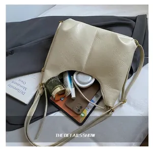 Top view of cream hobo bag with large capacity showing makeup items and gold hardware
