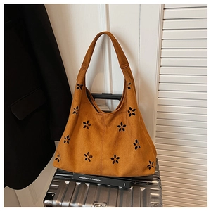 Sac fourre-tout en daim marron avec découpes fleuries sur une valise style urbain