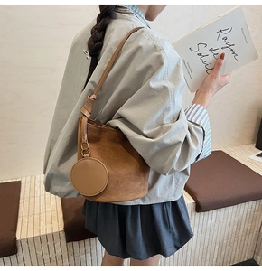 Détail du sac seau en daim marron avec un porte-monnaie rond amovible en pendentif