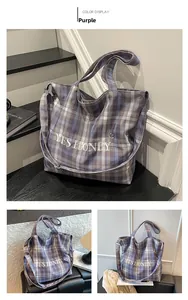 Detail of purple checkered tote bag featuring YES HONEY embroidery and smile pattern