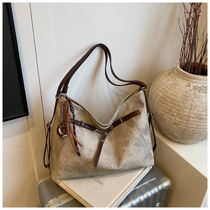 Detailed view of vintage tote bag with leather straps and artful pendant decoration