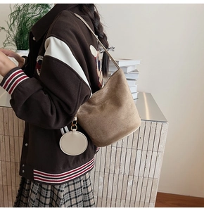 Détail d'un sac seau en daim marron avec porte-monnaie crème et garnitures dorées