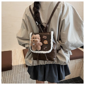 Detail view of mini retro plaid backpack with plush bear charm and white shearling trim