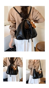 Detail of a black versatile tote bag used as a backpack with a cute brown bear charm