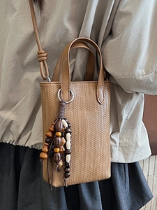 Minimalist woven brown mini crossbody bag with wooden bead fringe and vertical texture