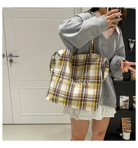 Close-up of a large plaid tote bag with Yes Honey print and yellow checkered pattern