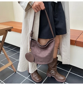 Détail d'un sac seau en daim marron avec une petite pochette ronde assortie amovible