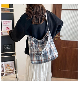 Detail of plaid tote bag with Yes Honey embroidery shown in a lifestyle setting