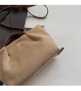 Détail du tissu en daim beige et poignée en cuir marron avec bouton-pression doré