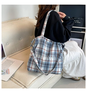 Close-up of plaid canvas tote bag with 'YES HONEY' embroidery and red blue pattern