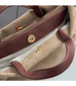Détail du sac en cuir à motif lézard montrant la fermeture éclair et la boucle dorée