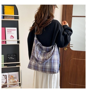Close-up of the large blue plaid tote bag showing embroidery and thick canvas fabric texture