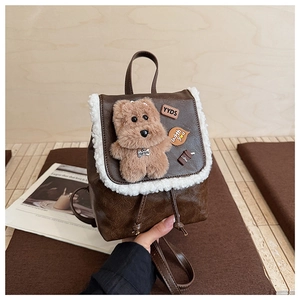 Detail of a brown leather backpack with fuzzy fleece trim and cute cartoon patches