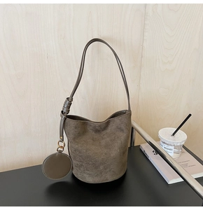Vue détaillée du sac seau en daim café avec bandoulière nouée et petite pochette ronde