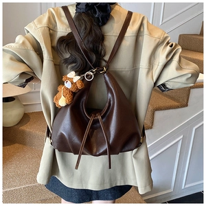 Close-up of soft dark brown PU leather tote bag with drawstring and cute bear charm