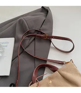 Détail de la bandoulière en cuir serpent réglable avec boucle en métal doré du sac seau