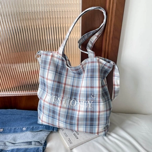 Detail of blue and white checkered tote bag with Yes Honey slogan and smiley print