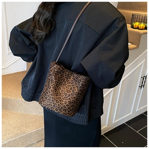 Fashionable leopard print bucket bag shown as a crossbody purse worn on a model back