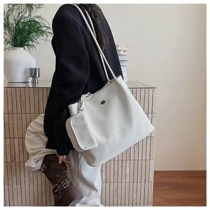 Dettaglio della borsa tote beige con pochette rimovibile e trama in pelle PU di qualità