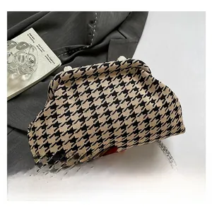 Detailed macro of a vintage houndstooth knit clutch bag with a sleek silver chain strap