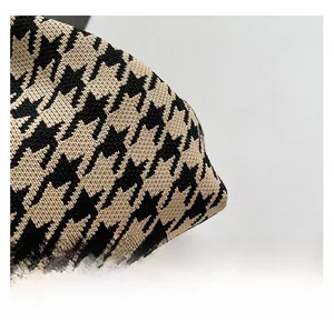 Close-up of premium houndstooth knitted fabric texture on the cloud handbag