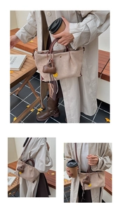 Détails d'un sac seau beige en faux suède avec anses en cuir et un charm sourire jaune