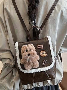Vintage brown leather backpack with cute teddy bear and plush trim worn by a model