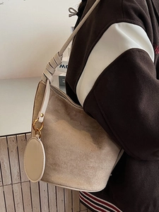 Sac seau minimaliste en daim beige pour femme avec pendentif rond et bandoulière cuir