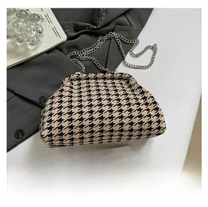 Macro detail of houndstooth crossbody bag with silver chain strap and phone size comparison
