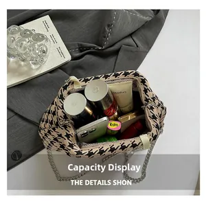 Detail showing the large interior capacity of this houndstooth canvas crossbody bag