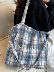 Blue and white checkered canvas tote bag with embroidered letters shown on model