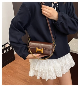 Vue détaillée du sac bandoulière en cuir marron avec un fermoir doré distinctif en H