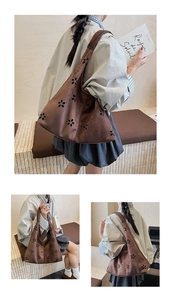 Detail of laser-cut floral pattern on dark brown faux suede hobo tote bag with wide strap