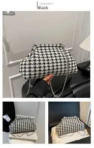 Detail of black and white houndstooth cloud bag with silver metal chain strap