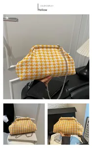 Detail of yellow and white houndstooth cloud bag with silver chain strap texture