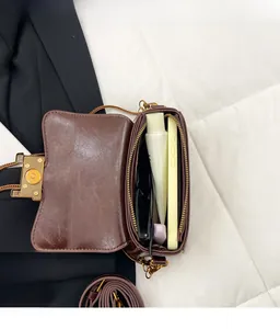 Vue intérieure d'un sac bandoulière en similicuir marron montrant sa grande capacité
