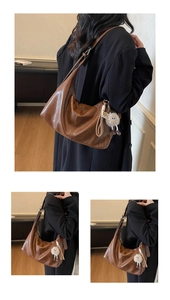 Detail of vintage brown large PU leather tote bag with a cute plush doll charm