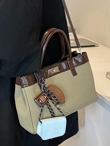 Retro canvas tote bag with brown leather trim and stylish charms for daily commuting